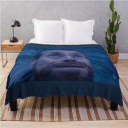 Willem Dafoe looks up a throw blanket