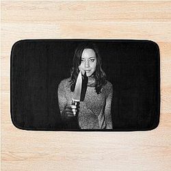 Aubrey Plaza holding a black knife on a bath mat