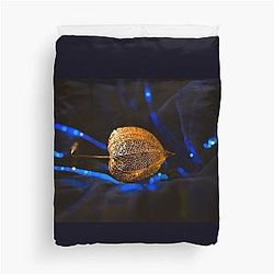 Golden seed pod on blue velvet duvet cover
