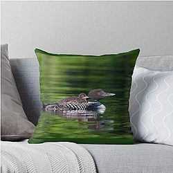 Common loon swimming with chick on her back Throw Pillow