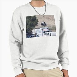 Kanye West riding an ATV in a sweatshirt